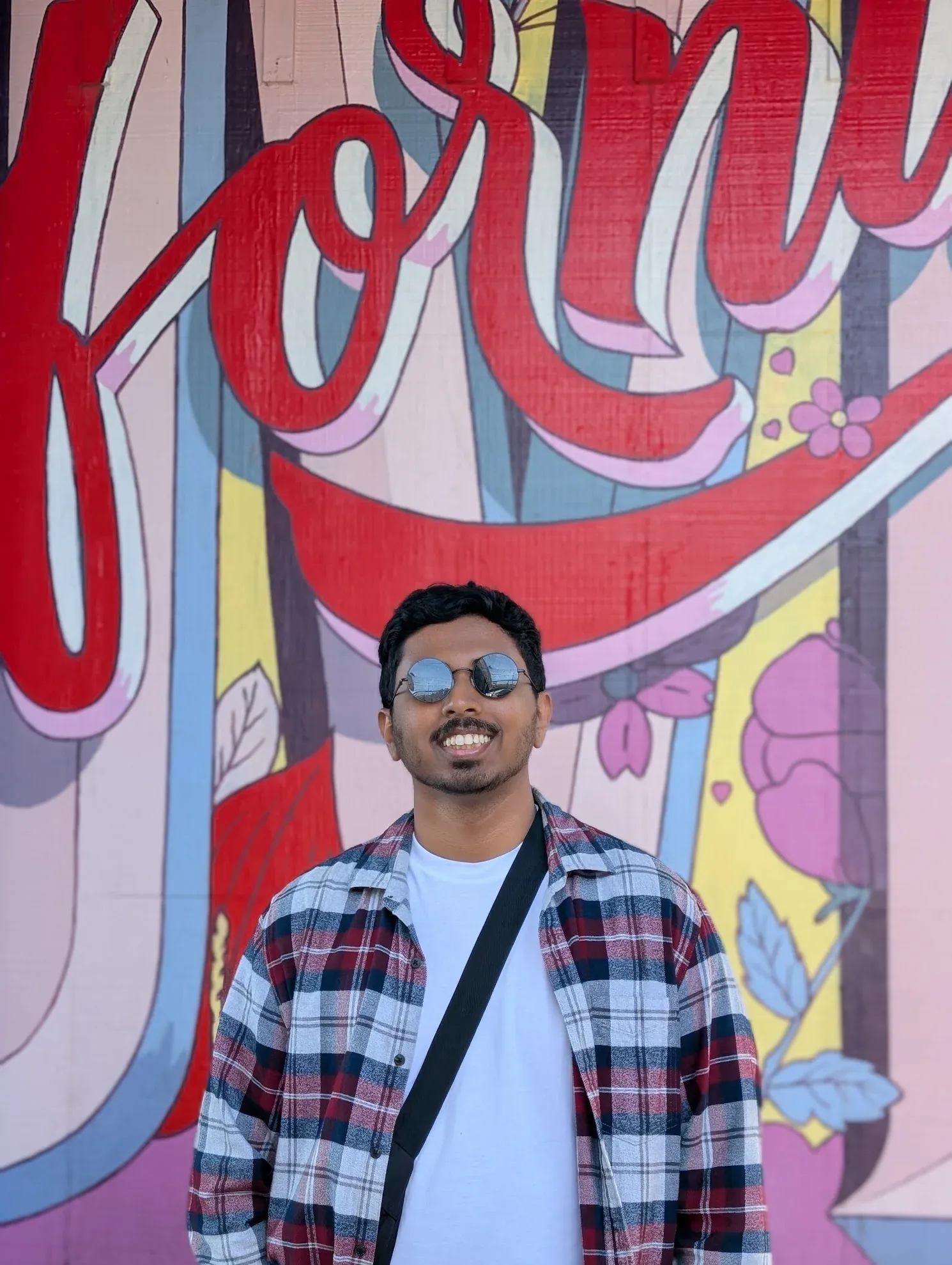 Raheeb Hassan in front of a painted mural